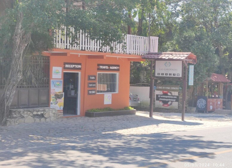 A small reception and travel agency office with a sign for Las Gardenias Hotel. 4