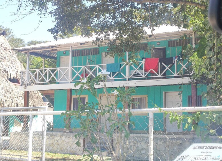 A two-story building with green walls and white railings. 2
