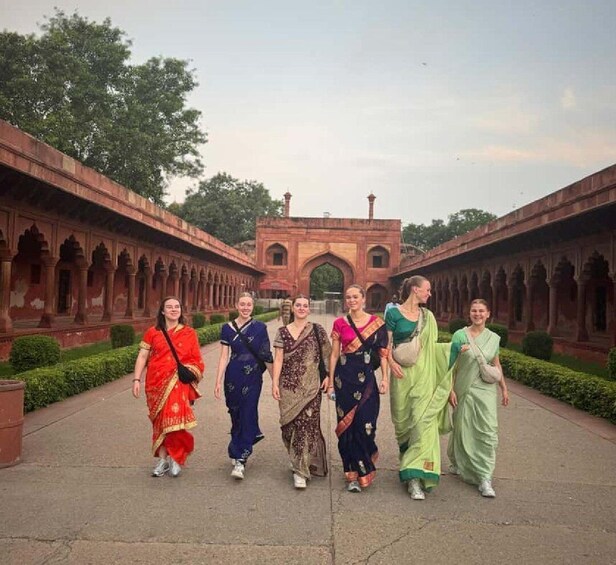 A group of people walking in a courtyard with arches and a central gateway. 3