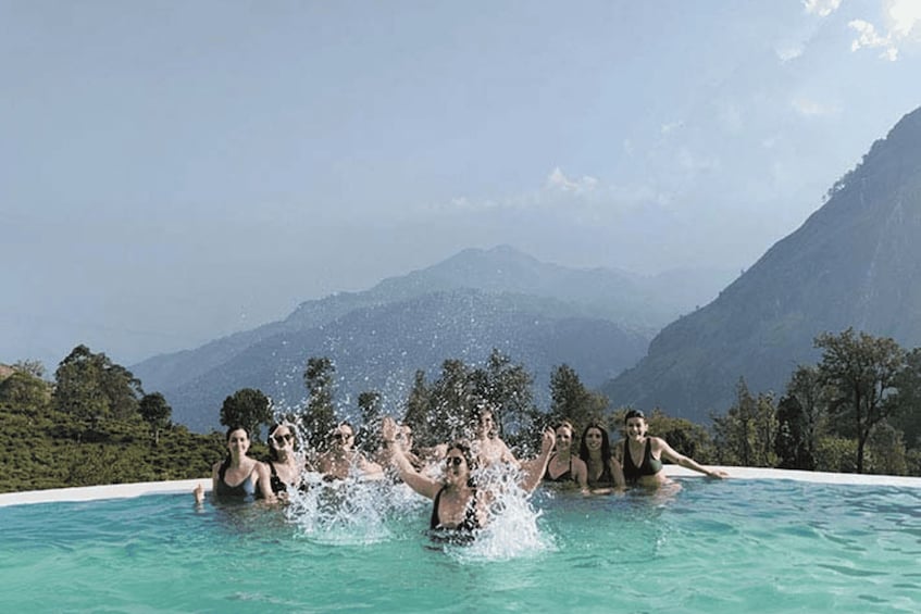 A group of people in a swimming pool with a mountainous landscape in the background. 3
