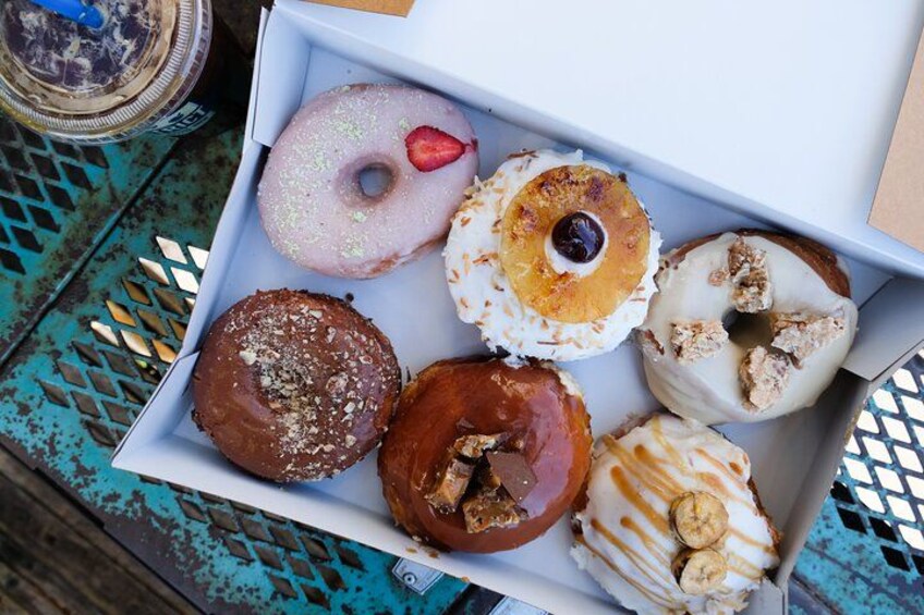 Een doos met een verscheidenheid aan donuts, met verschillende toppings en glazuur. 2