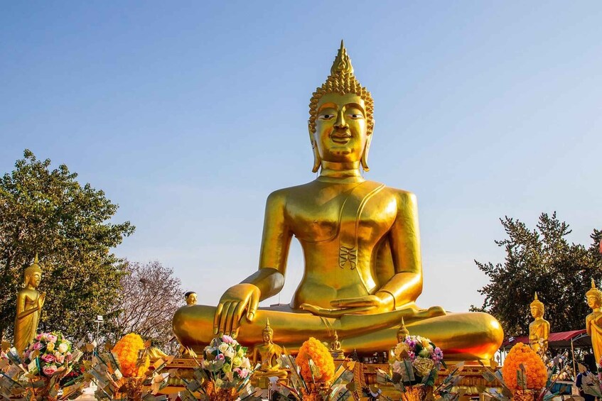 A large golden Buddha statue surrounded by smaller statues and offerings. 4