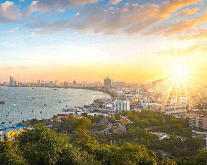 A coastal cityscape with a sunset, buildings, and boats on the water. 3