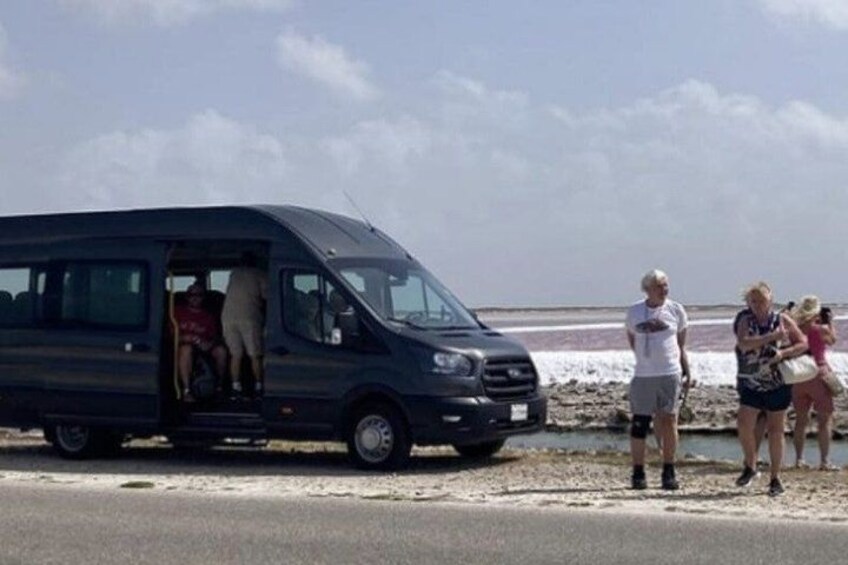 Una camioneta negra estacionada en la playa con gente cerca. 4