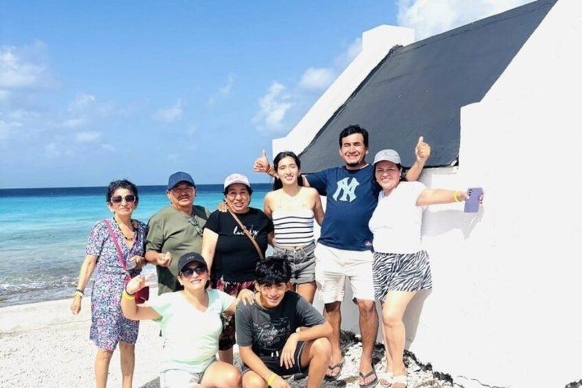 Un grupo de personas en una playa con cielo despejado y mar tranquilo. 5