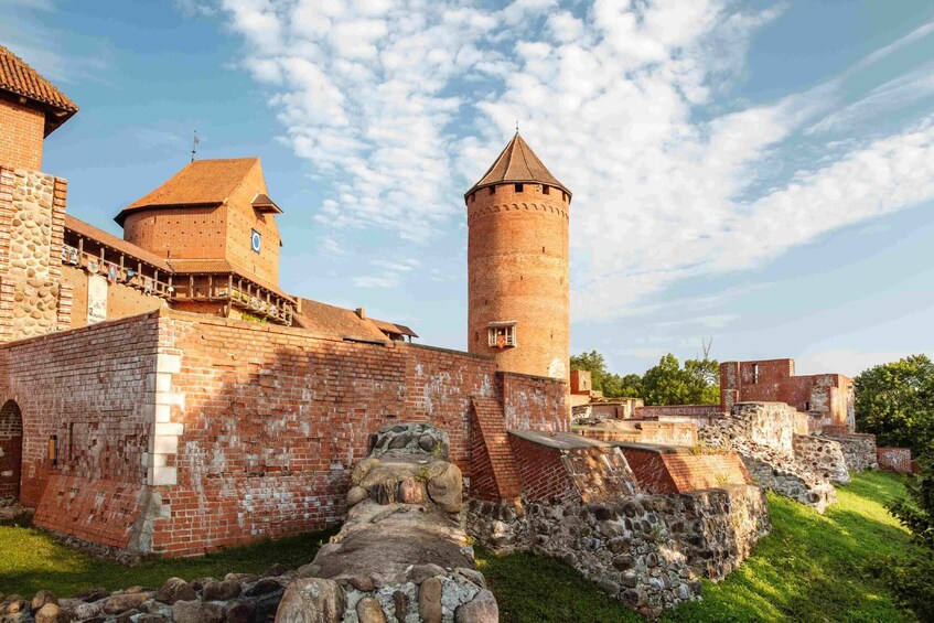 A historic brick castle with a prominent tower and a fortified wall. 3