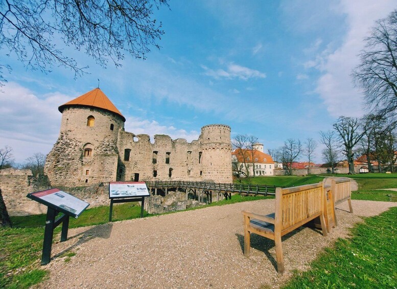 A historic castle with a round tower and a bridge leading to it. 5