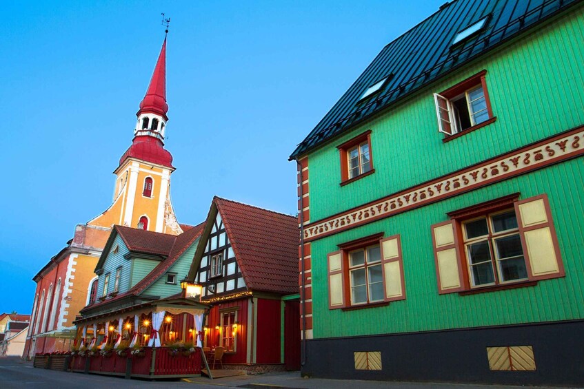 A church with a red spire and a building with green walls and red trim. 4