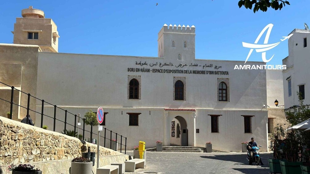 A white building with a tower and arched entrance, labeled 'BORJ EN-NAAM - ESPACE D'EXPOSITION DE LA MEMOIRE D'IBN BATTOUTA'. 4