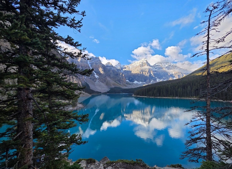 A clear blue lake surrounded by mountains and trees. 3