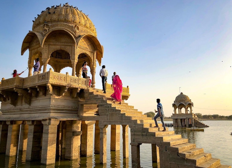 A historical structure with intricate carvings and a dome, situated over a body of water. 4
