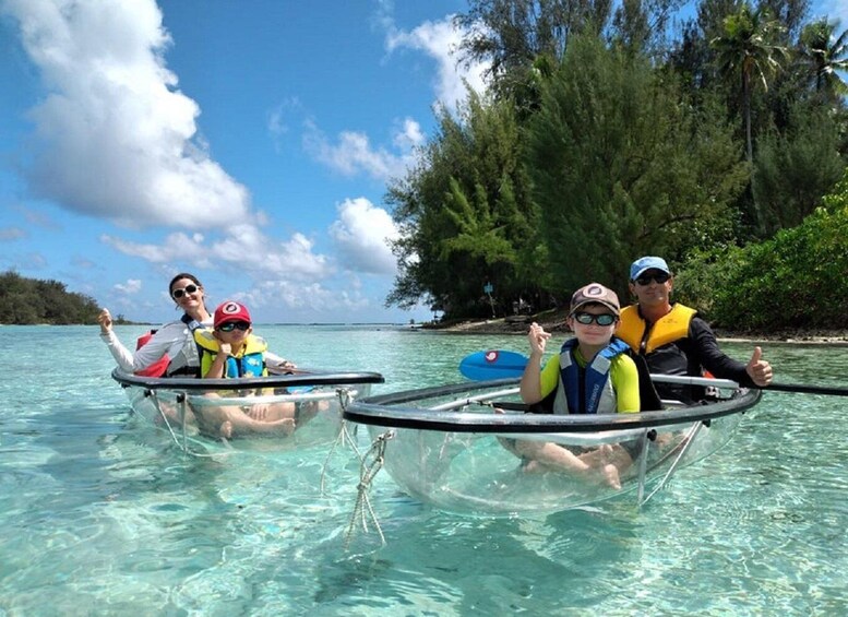 People in transparent kayaks on clear turquoise water, surrounded by tropical vegetation and palm trees. 3