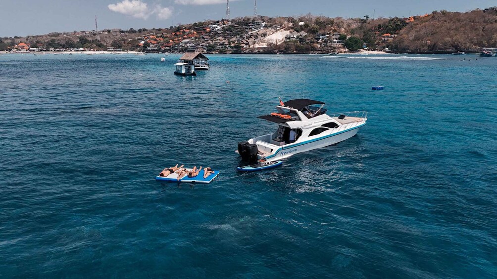 A large yacht named Freedom on a calm sea with a small inflatable boat nearby. 5
