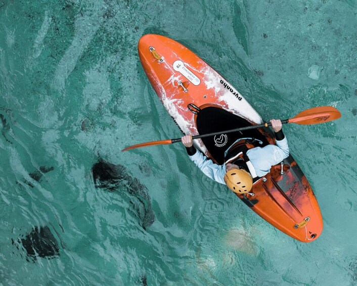 A person kayaking on a turquoise body of water. 2