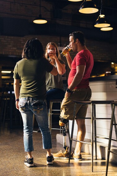Two people standing at a bar counter in a restaurant. 3