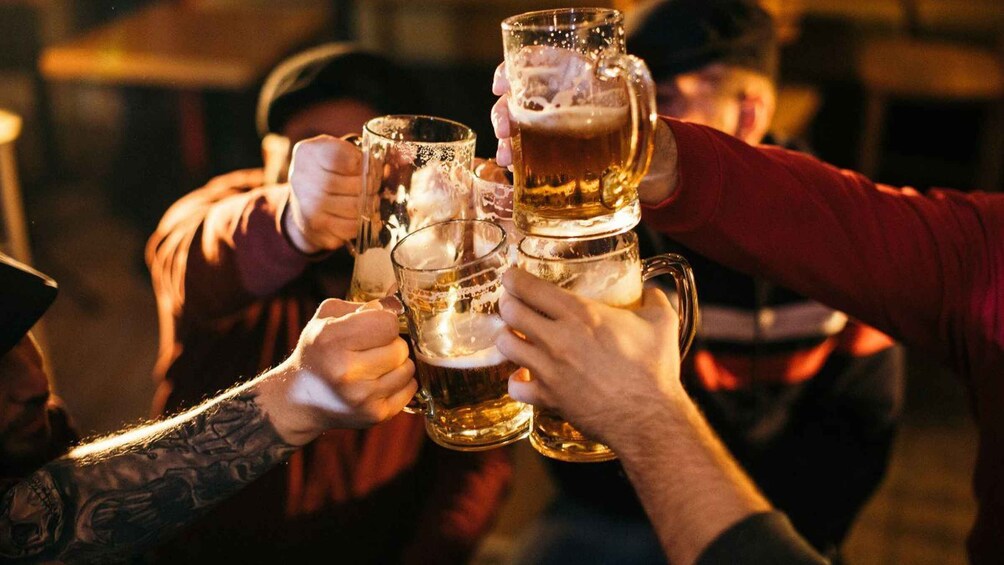 People clinking beer mugs together. 1