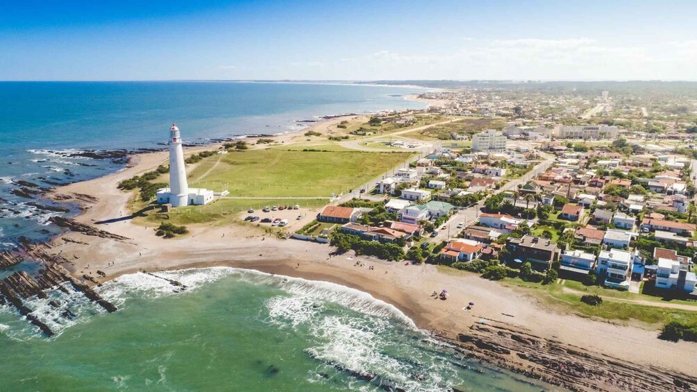 A coastal town with a lighthouse, beach, and residential area. 1
