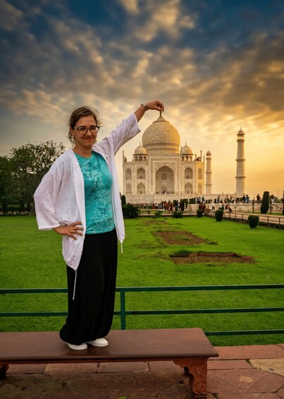 En person som står på en bänk med Taj Mahal i bakgrunden. 4