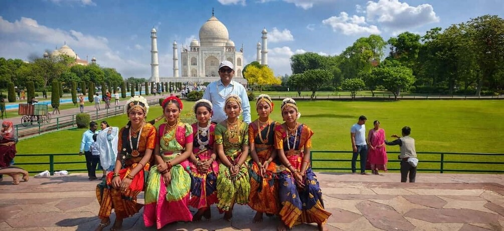 En grupp människor i färgstarka, traditionella dräkter framför Taj Mahal. 2