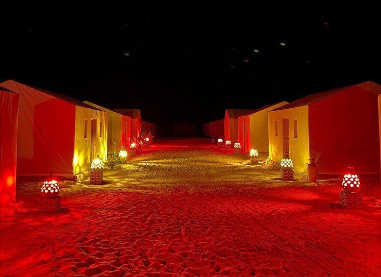 A row of tents with red lighting, a cobblestone path, and brick lanterns. 2