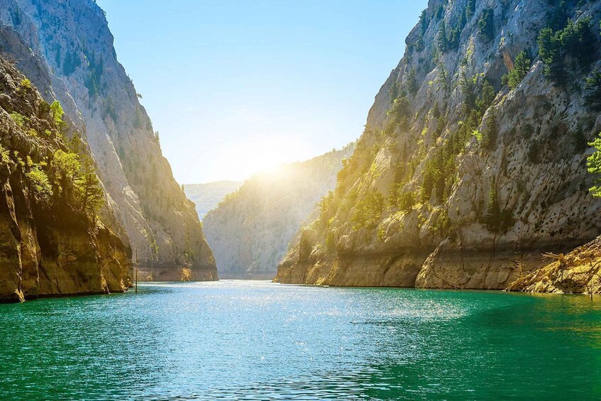 A canyon with turquoise water and rocky cliffs. 1