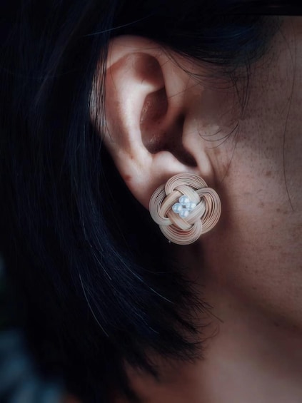 A close-up of a person's ear with a large, intricate earring. 3