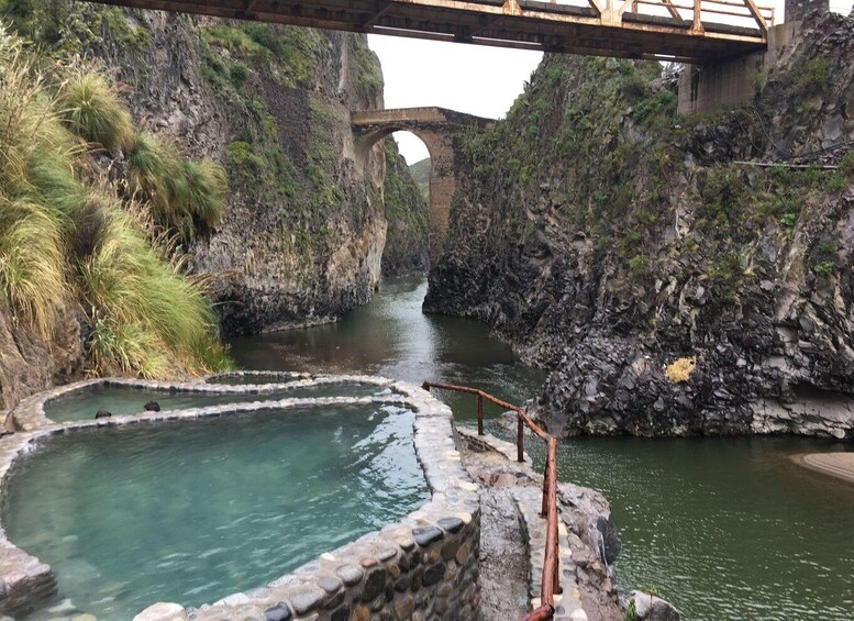 A stone bath area with a wooden bridge overhead. 2