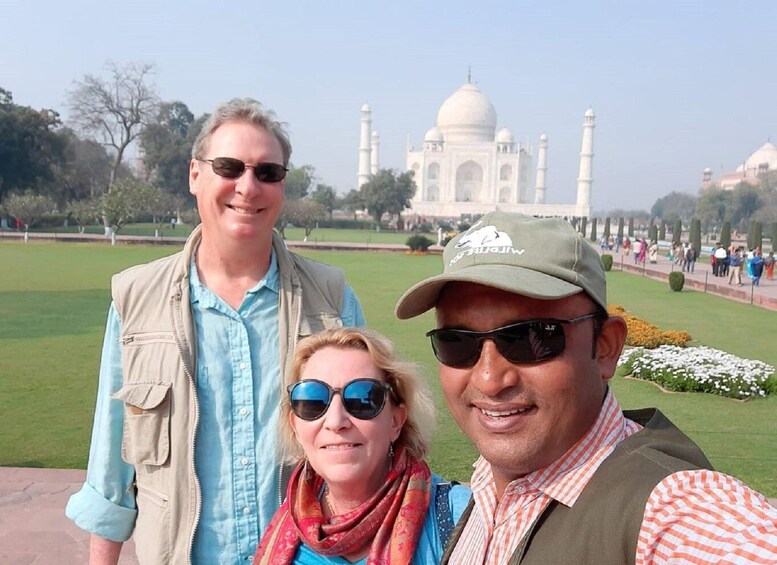 Kolme ihmistä Taj Mahalin edessä. 3