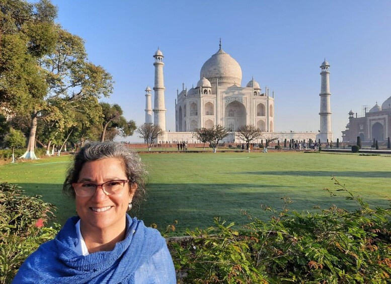 Siniseen huiviin pukeutunut henkilö Taj Mahalin edessä. 5