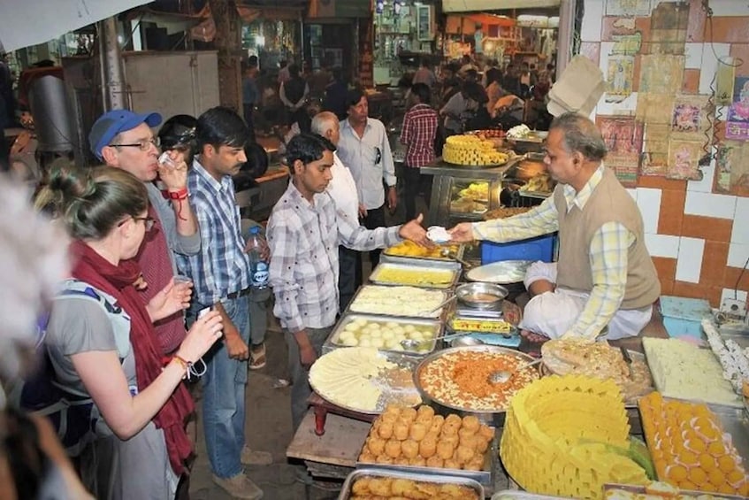 A crowded street food market with various food stalls and people. 3
