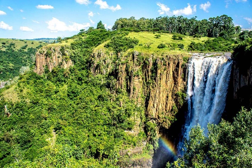 A waterfall cascading down a steep cliff surrounded by lush green forest. 4