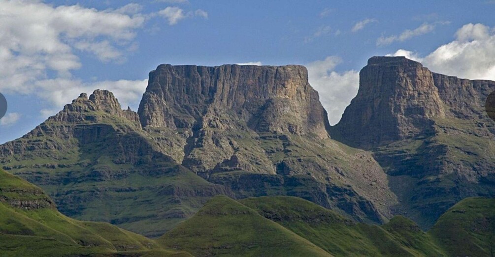 A mountain range with prominent cliffs and green valleys. 5
