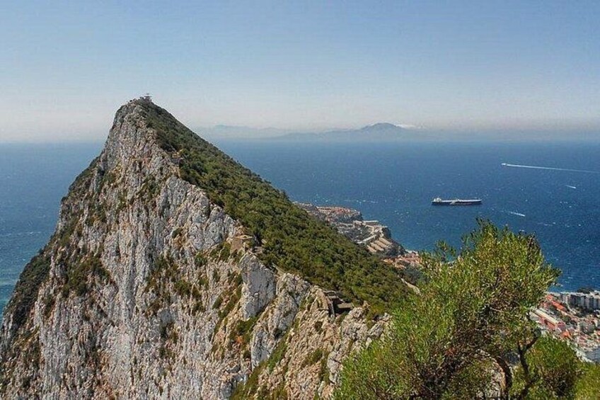 A mountainous landscape with a clear view of the sea and a ship in the distance. 5