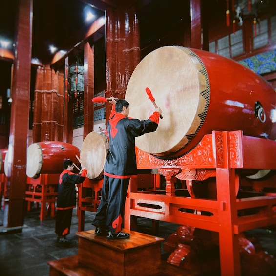 A person playing a large drum in a workshop. 1