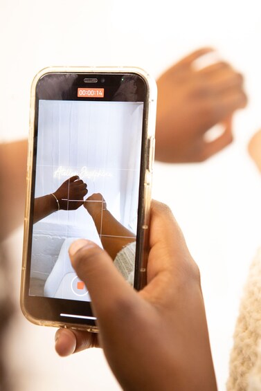 A person holding a smartphone displaying a video with a timer. 3