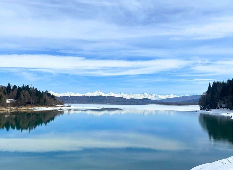 A calm lake with snow-capped mountains in the background and a clear sky. 3