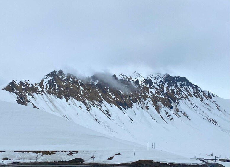 A snow-covered mountain range with a cloudy sky. 2