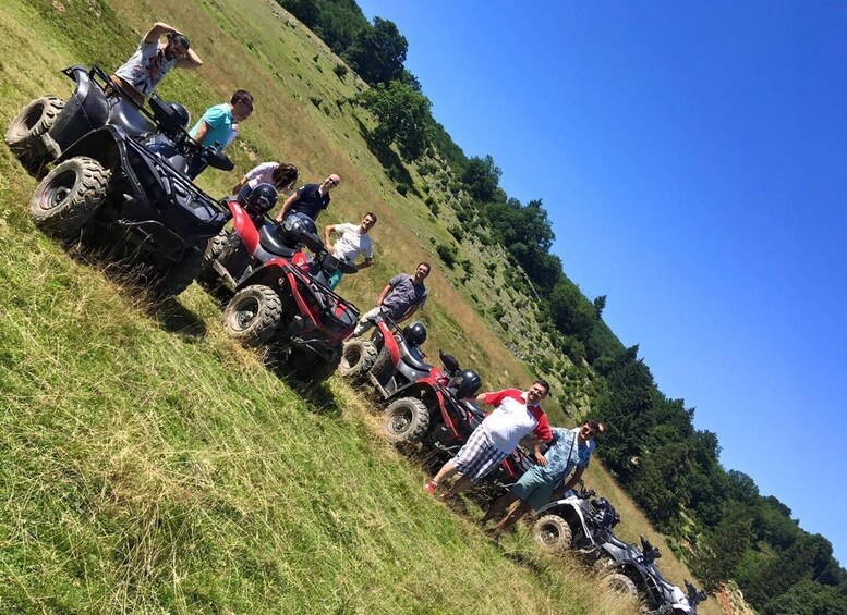 A group of people on ATVs on a grassy hillside. 3