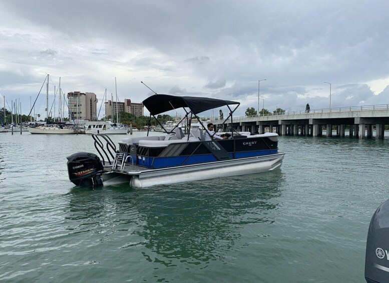 A boat named 'Crest' docked at a marina with a bridge in the background. 2