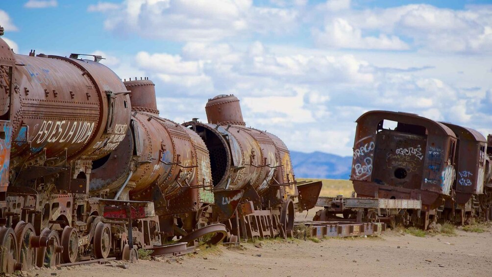 Rusted, abandoned train cars in a desert landscape. 4