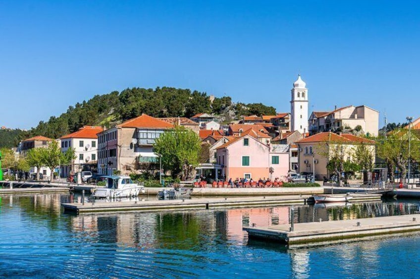 Une ville côtière avec des bâtiments, un quai et une tour. 2
