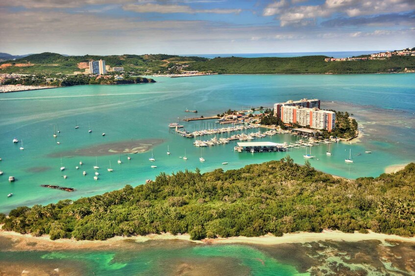 An aerial view of a coastal area with a marina, boats, and a hotel. 4
