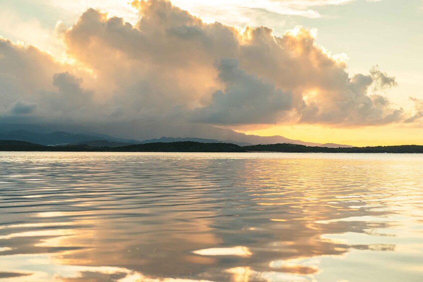 A calm lake with reflections of clouds and mountains in the background. 2