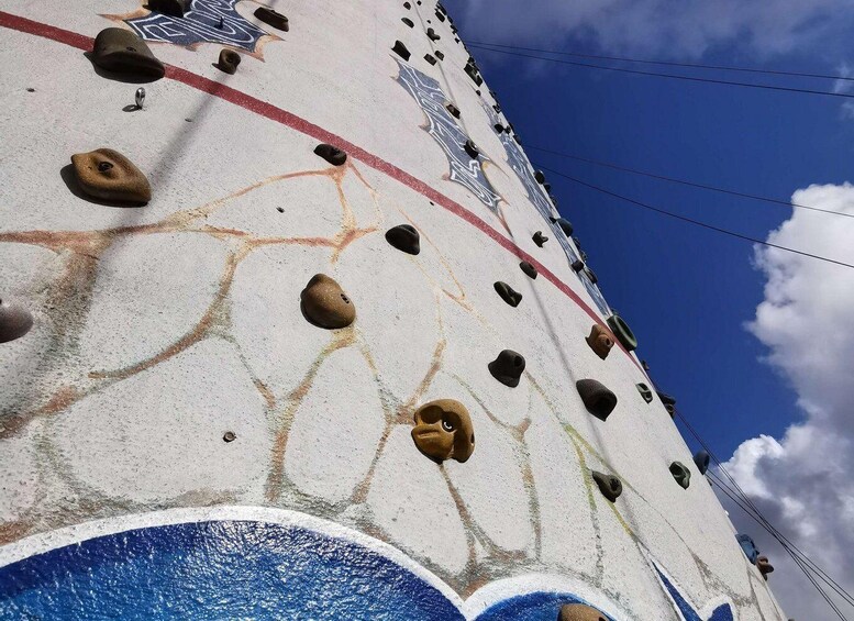 A climbing wall with handholds and a painted design. 2