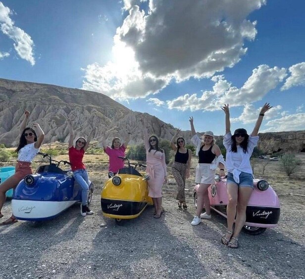 Six people on vintage cars in a desert landscape. 1