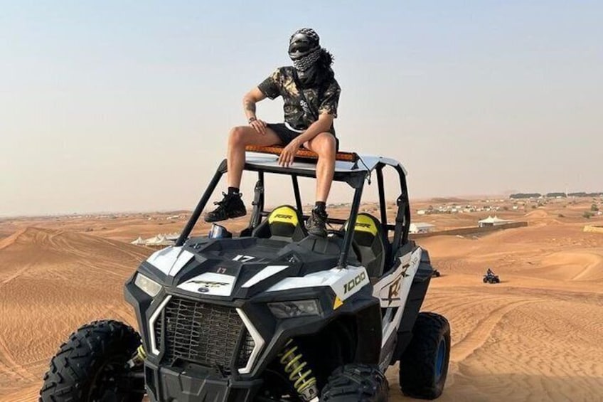 Une personne assise sur un véhicule tout-terrain dans un paysage désertique. 4
