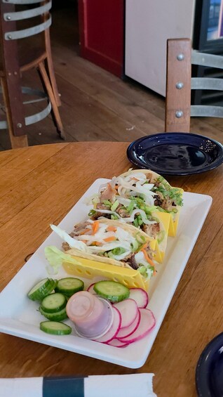 Lautasella on tacoja, joiden täytteenä on silputtuja salaatinlehtiä, raastettuja porkkanoita ja viipaloituja kurkkuja. 5