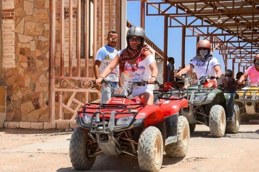 Persone che guidano quad attraverso una strada sterrata. 1