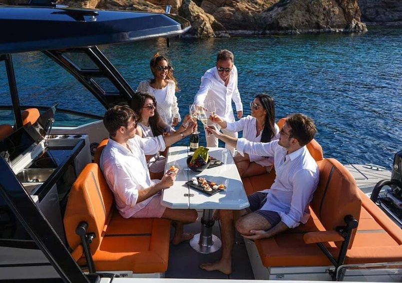 A group of people on a boat with a table, enjoying drinks and food. 4