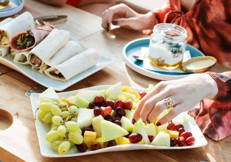 A table with food items including fruit and wrapped dishes. 3